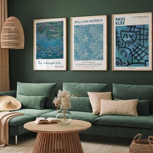 May include: A living room with a green sofa, a wooden coffee table, and three framed art prints. The prints display floral patterns and abstract art. A woven lamp and decorative items complete the interior design.