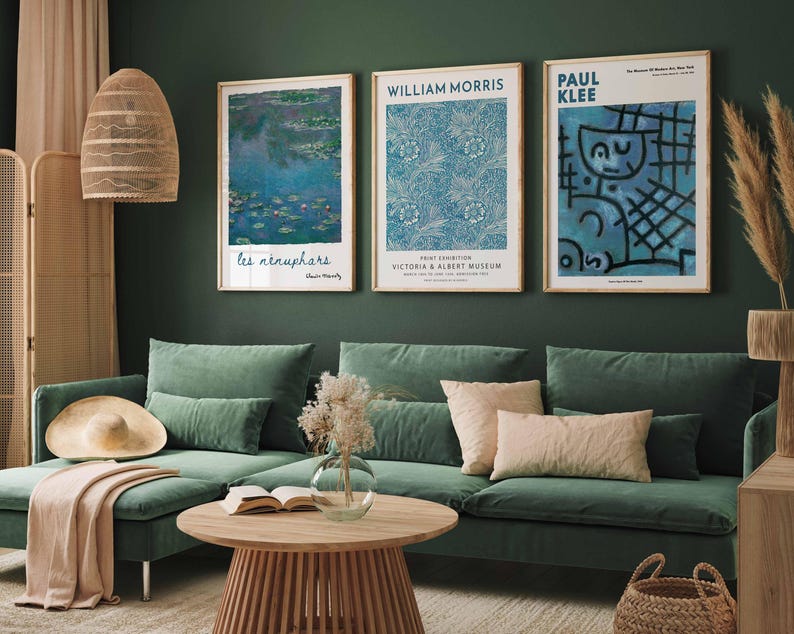 May include: A living room with a green sofa, a wooden coffee table, and three framed art prints. The prints display floral patterns and abstract art. A woven lamp and decorative items complete the interior design.