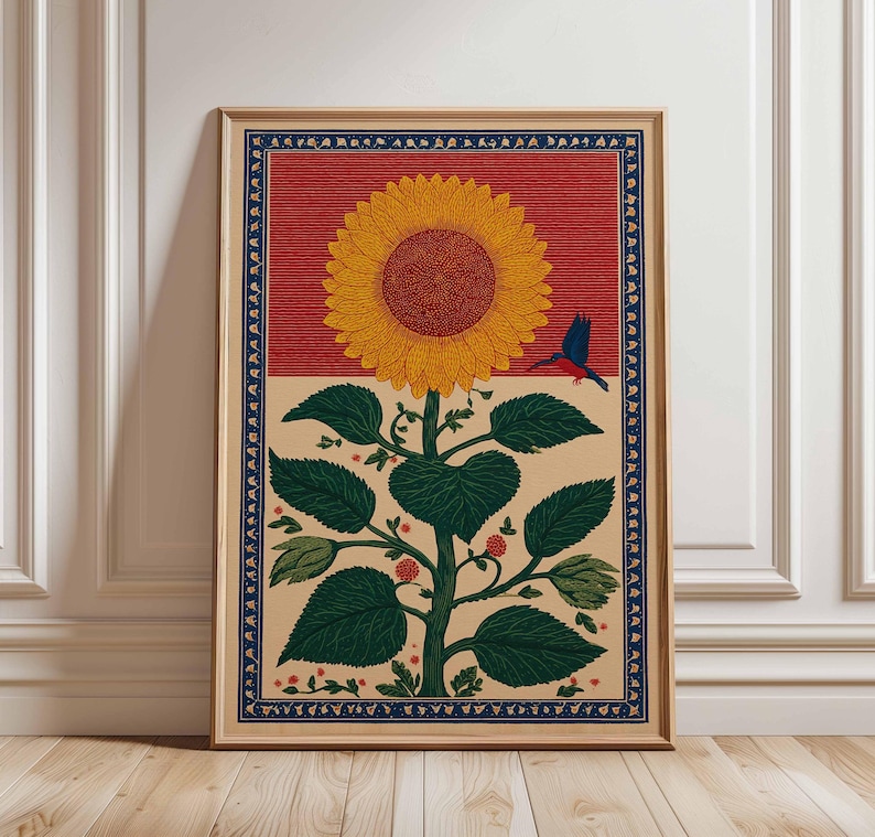 May include: A framed art print featuring a stylized sunflower with a large yellow bloom and a red and tan background. A blue bird is perched near the flower. The print has a dark blue border and is set in a wooden frame.