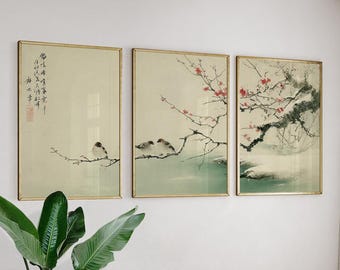 May include: Three framed art prints with Japanese-style paintings. Each print has a gold frame and depicts birds on branches, with cherry blossoms and calligraphy. The artwork has a soft, muted colour palette.