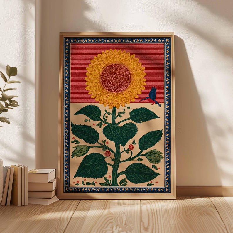 May include: A framed art print featuring a stylized sunflower with a red background and a blue bird. The sunflower has yellow petals and a brown center. The artwork has a beige border with a blue decorative trim.