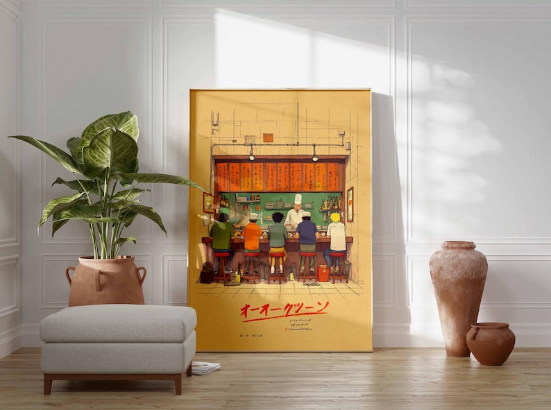 May include: A framed illustration depicts a ramen shop scene with patrons seated at a counter. The artwork features a chef and customers, with Japanese text at the bottom. The color palette includes warm tones of yellow, orange, and brown.