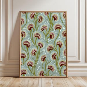 May include: A framed vertical wall art print featuring a repeating botanical pattern of stylized Venus flytrap plants. The design showcases deep red and white traps with olive green stems set against a muted light blue background with white dots.