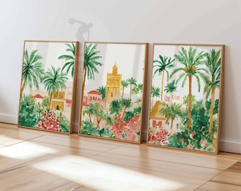 May include: Three framed watercolor prints depicting a vibrant cityscape with palm trees, buildings, and lush greenery. The artwork features warm tones of gold, pink, and green, creating a tropical and inviting scene. The frames are a natural wood color.