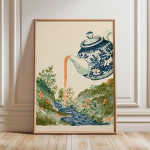 Puede incluir: Una lámina de arte mural enmarcada que muestra una tetera con estampado floral azul y blanco suspendida en el aire, vertiendo un chorro de líquido naranja en un río azul serpenteante que fluye por un paisaje verde con árboles y un puente.