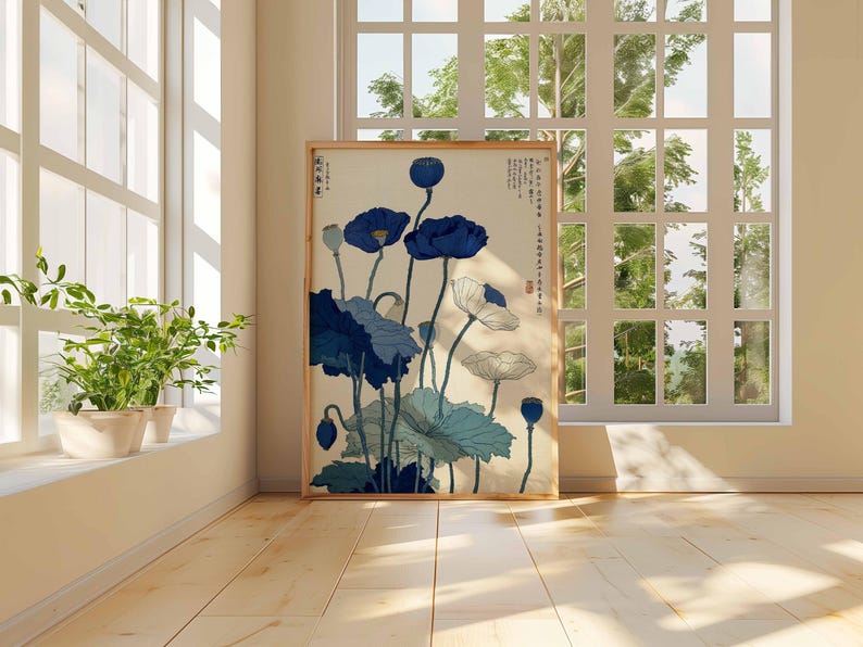 May include: A framed art print featuring a botanical illustration of blue and white flowers with green leaves. The artwork is displayed in a room with a window and natural light. The print has Japanese text.