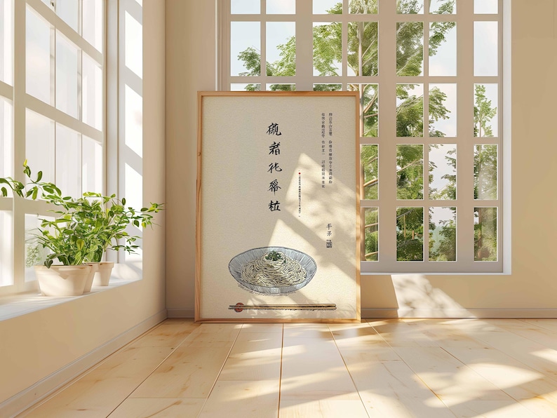 May include: A framed print featuring a bowl of noodles with chopsticks, set against a light background. The print includes Chinese characters and is displayed in a room with a window and plants.