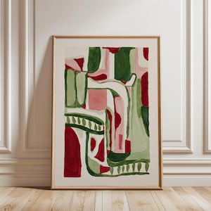 Pode incluir: Impressão de arte abstrata emoldurada em madeira. A obra apresenta uma composição de formas verdes, vermelhas e rosa sobre um fundo branco. As formas incluem retângulos, curvas e linhas, criando um design moderno e colorido.