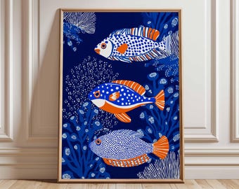 May include: A framed art print featuring three stylized fish in a marine setting. The fish are white, blue, and orange, with dotted patterns and detailed fins. The background is a deep blue with white and blue coral-like elements.