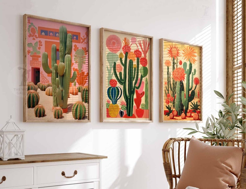 May include: Three framed illustrations of cacti in a desert landscape. The illustrations are in a retro style with bright colors and bold lines. The cacti are green, pink, and orange. The background is a light pink, yellow, and orange.