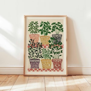 May include: A framed art print featuring nine potted plants in colorful, patterned pots. The plants are various shades of green, and the pots are pink, yellow, black, purple, and red. The print has a cream background and a red and white checkered shelf.