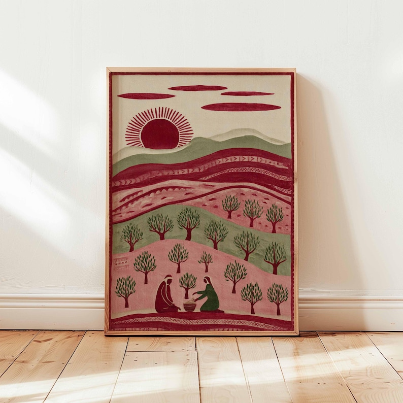 Puede incluir: Una impresi&oacute;n art&iacute;stica enmarcada que representa un paisaje. La obra presenta un sol rojo, colinas y &aacute;rboles en tonos verdes y rosas. Dos figuras est&aacute;n sentadas en primer plano. La impresi&oacute;n se exhibe sobre un suelo de madera.