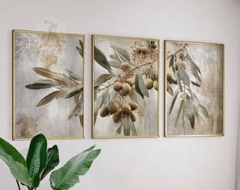 May include: Triptych of framed botanical art prints. Each print features olive branches with green leaves and olive fruit, set against a textured, neutral background. The frames are gold-colored, adding a touch of elegance to the artwork.