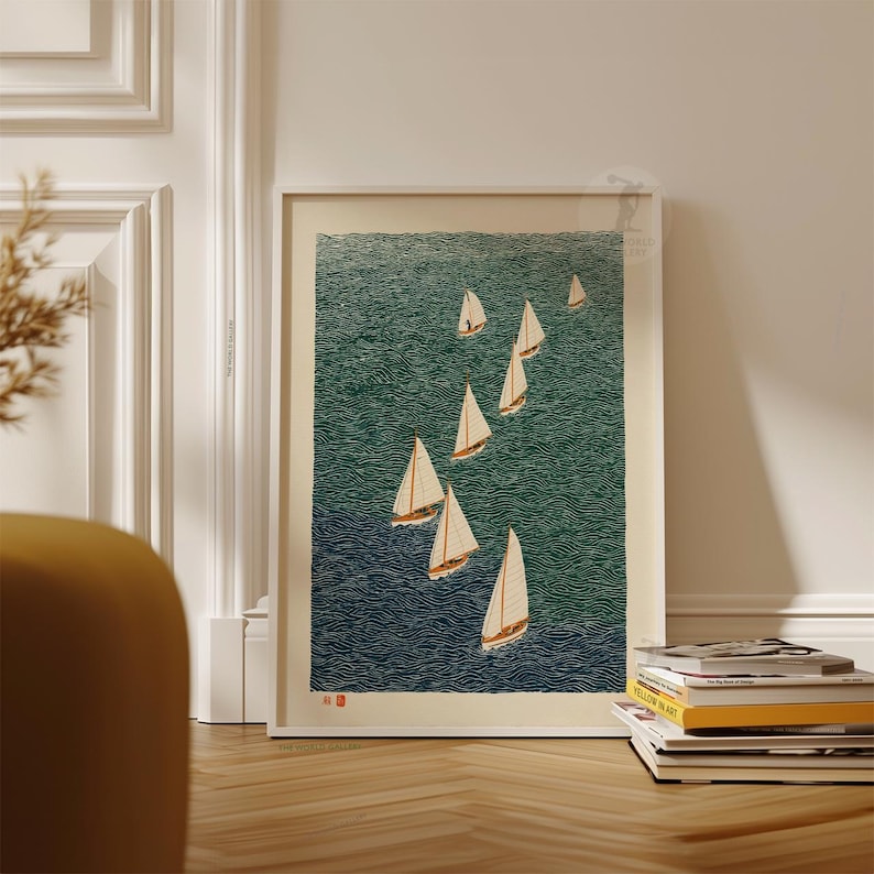 May include: A framed art print featuring a nautical scene with several sailboats on a textured teal and navy blue ocean. The sailboats have white sails and brown hulls. The print is displayed on a wooden floor.