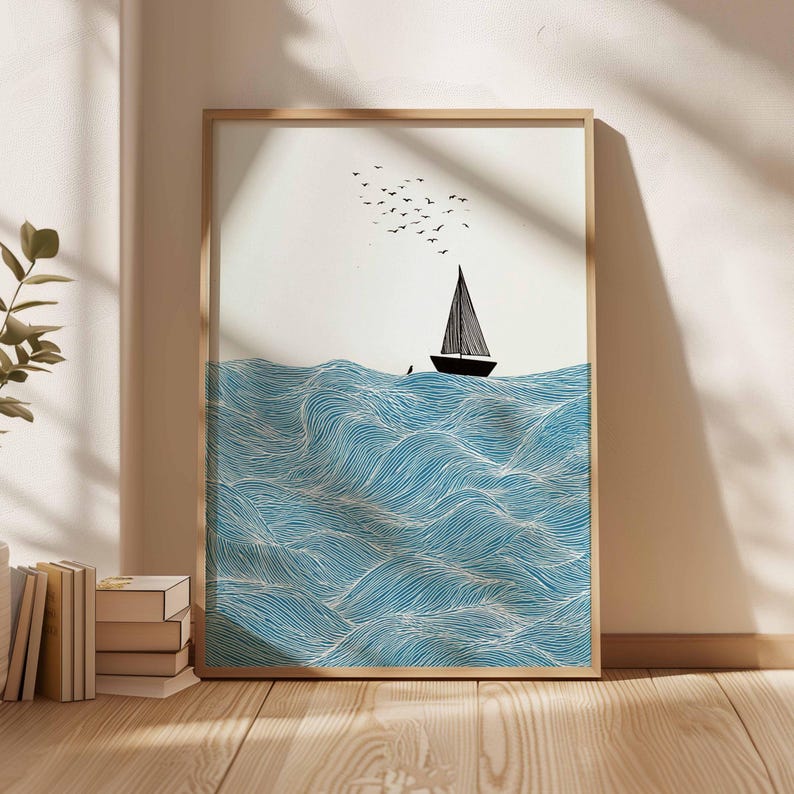 May include: A framed art print featuring a sailboat on blue waves with a flock of birds in the sky. The artwork has a minimalist style with a black sailboat and white and blue wave details.