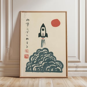 以下が含まれることがあります： 黒いロケットが濃い緑色の煙の雲から打ち上げられる様子を描いた、額装されたアートプリント。背景には赤い太陽が描かれています。左側には日本語の文字が印刷されています。木製のフレームに入っています。