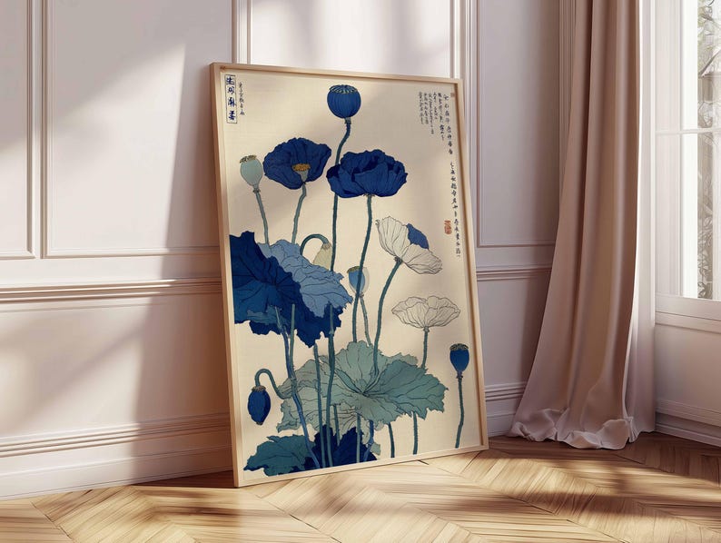 May include: Framed art print featuring a botanical illustration of blue and white poppies. The artwork has a vintage aesthetic with Japanese-inspired elements. The print is displayed against a cream-colored background, with a wooden frame.