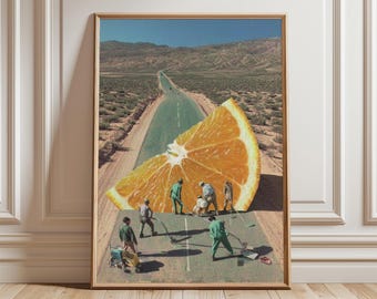 May include: Framed art print featuring a surreal collage. A large orange slice is positioned on a desert road, with miniature figures appearing to work on the road. The background shows a long road leading to distant mountains under a blue sky.