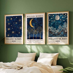 Op de afbeelding: Drie ingelijste prints met een gouden lijst en een witte passe-partout. Elke print heeft een blauw en gouden ontwerp met de tekst "William Morris" en de titel van de print. De prints zijn getiteld "A Midsummer's Night", "Cotton Prints Exhibition" en "A Tapestry Patch for the Moonlit Line".