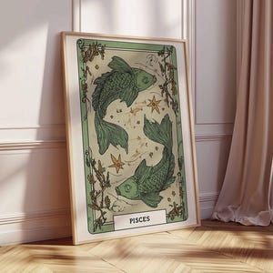 May include: A framed art print featuring a green illustration of two fish, representing the Pisces zodiac sign. The artwork has a vintage aesthetic with botanical elements and star details. The print is in a light wooden frame.