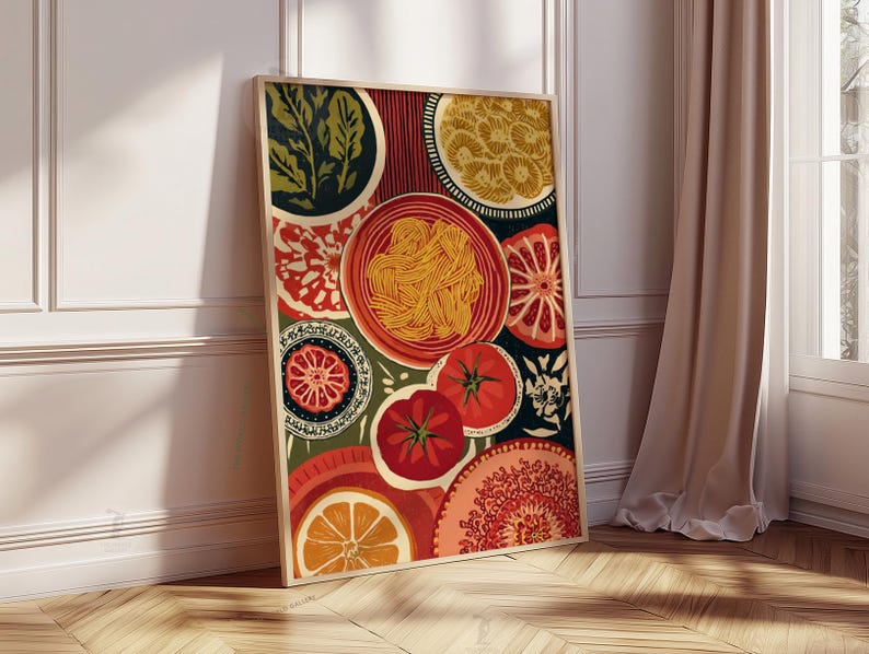 May include: A framed art print featuring a colorful still life of food. The artwork includes images of pasta, tomatoes, oranges, and decorative plates in shades of red, orange, green, and yellow. The print is leaning against a white wall and a wooden floor.