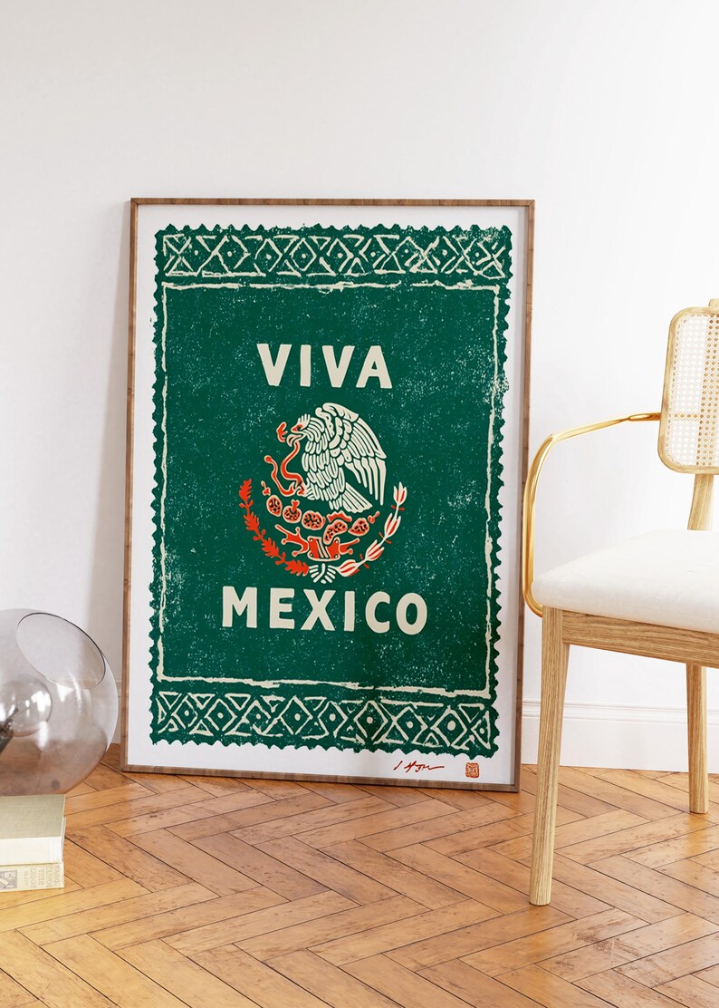 May include: A framed print featuring the Mexican coat of arms, with the words "VIVA MEXICO" in white on a green background. The print has a distressed, vintage look and is framed in a wooden frame.