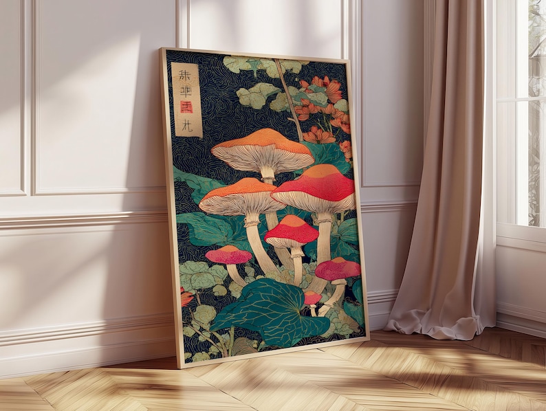 May include: A framed art print depicting stylized mushrooms in red, orange, and pink against a dark blue backdrop. The artwork includes green foliage and Japanese text. The print is displayed on a wooden floor. The frame is a light brown color.