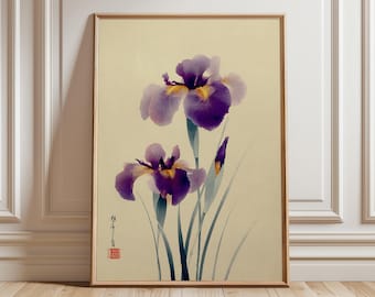 May include: A framed print featuring two purple iris flowers with yellow centers and green stems against a cream background. The artwork has a traditional Japanese aesthetic, with delicate brushstrokes and a minimalist style. The frame is a light wood color.