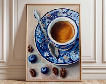 May include: A framed painting depicts a cup of coffee on a blue and white patterned saucer with a matching cup. A silver spoon rests in the cup. Scattered around are blueberries and coffee beans. The artwork is set against a neutral background.