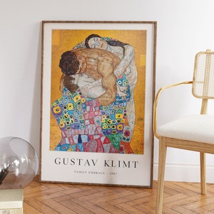 May include: A framed poster of Gustav Klimt's painting "Family Embrace" from 1907. The painting depicts a family in a warm embrace, with a mosaic-like pattern on the woman's dress. The poster has a gold frame and a white background with the artist's name and the title of the painting.