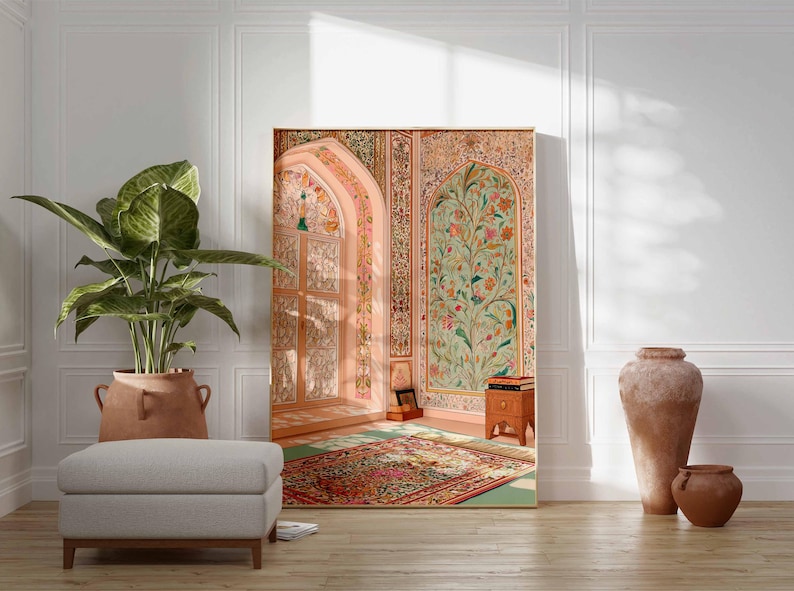 May include: A large framed artwork showing an ornate interior scene with floral and architectural details in soft pinks, greens, and golds. A large potted plant, a grey ottoman, and terracotta vases are in the foreground. The artwork leans against a white wall.