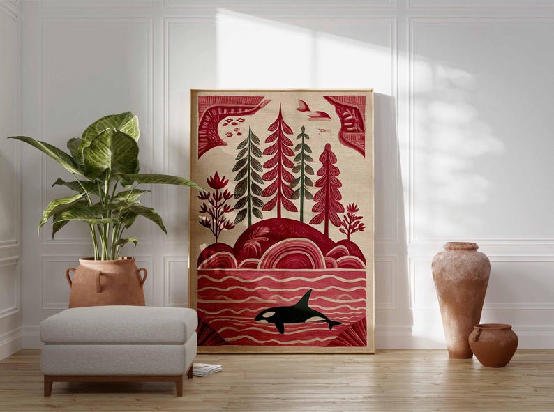 May include: A framed art print featuring a stylized landscape with red and green trees, a red ocean, and a black and white orca. The artwork has a beige background and is displayed in a room with a plant, ottoman, and decorative vases.