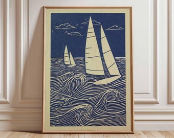May include: Framed print depicting two sailing boats on a choppy sea under a cloudy sky. The artwork uses shades of blue and cream, with a wood-grain frame. The print is displayed on a wooden floor. The artwork is in a wooden frame.