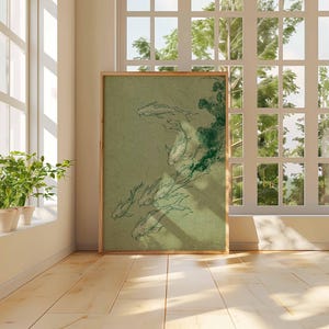 May include: A framed art print featuring a green and white illustration of koi fish. The artwork is displayed on a wooden floor, leaning against a wall near a window. The room has a neutral color palette with natural light.