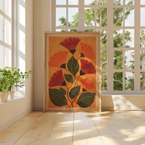 May include: A framed floral art print featuring stylized red and orange flowers with green leaves against a warm yellow background. The artwork is displayed on a light wood floor near a window, creating a bright and airy atmosphere.