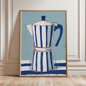 May include: A framed art print of a coffee maker. The coffee maker is white with blue vertical stripes and a blue handle, set against a light blue background. The artwork is framed in a natural wood tone.