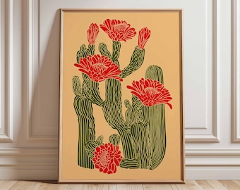 May include: A framed art print depicting a stylized illustration of cacti with red flowers on a tan backdrop. The cacti are green with detailed line work, and the flowers are a vibrant red. The artwork is in a wooden frame.