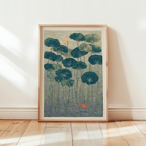 May include: Framed art print featuring a serene pond scene with large, teal lily pads and a small orange fish. The artwork has a vintage aesthetic, with a light blue and green color palette. The print is in a wooden frame.