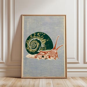 May include: A framed print featuring a stylized snail illustration. The snail's shell is dark green with a yellow spiral, and the body is red and white against a light blue background. The artwork is in a wooden frame.