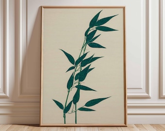 Puede incluir: Una impresión enmarcada que presenta una ilustración estilizada de bambú. La obra de arte muestra tallos y hojas de bambú verde-azulado sobre un fondo crema. El marco es de color marrón claro. La impresión se exhibe sobre un suelo de madera.