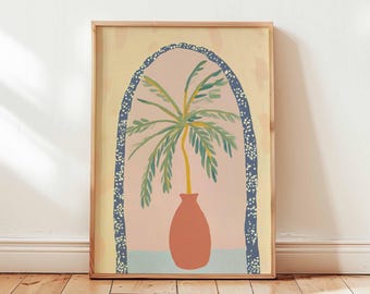 May include: A framed art print depicting a palm tree in a terracotta vase. The artwork is set against a soft pink backdrop within a blue and white dotted arch, framed by a natural wood border. The background is a light yellow.