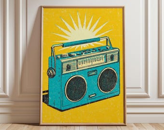 May include: A framed retro-style illustration of a teal boombox against a yellow background with a sunburst design. The boombox has two speakers, a handle, and a radio dial. The artwork is displayed on a wooden floor.