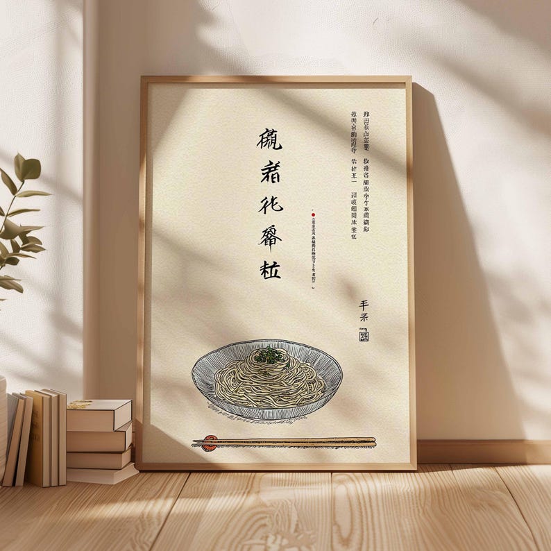 May include: A framed art print featuring a bowl of noodles with chopsticks. The artwork has Chinese characters and a drawing of noodles in a bowl. The frame is made of light-colored wood.