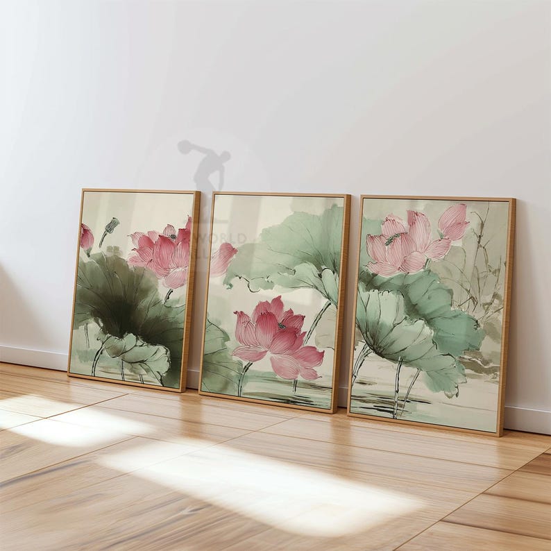 May include: Three framed art prints featuring watercolor paintings of pink lotus flowers and green leaves. The artwork has a traditional Asian style, with soft colors and delicate brushstrokes. The frames are a light wood color.