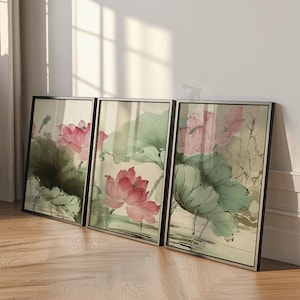 May include: Three framed art prints featuring watercolor paintings of pink lotus flowers and green leaves. The artwork has a traditional Asian style, with soft colors and delicate brushstrokes. The frames are black.