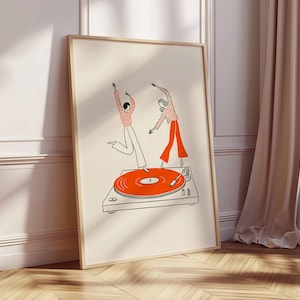Puede incluir: Una impresi&oacute;n art&iacute;stica enmarcada con una ilustraci&oacute;n caprichosa de dos figuras bailando sobre un tocadiscos. Las figuras est&aacute;n representadas en rojo y blanco, con el tocadiscos en naranja y gris. La obra de arte tiene un estilo minimalista y un fondo crema.