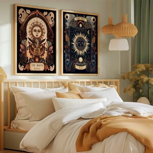 May include: Two framed illustrations of the sun and moon with intricate details and floral accents. The sun illustration features a face with a crown and the moon illustration features a crescent moon with stars. The frames are black and the illustrations are on a dark background.