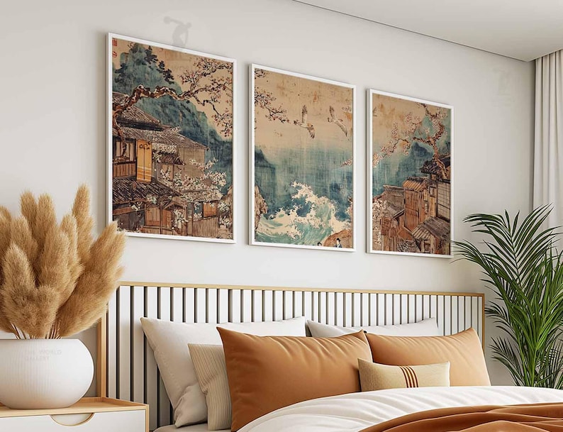 May include: Three framed prints of Japanese art depicting traditional houses and landscapes. The prints are in a white frame and are hung on a white wall.