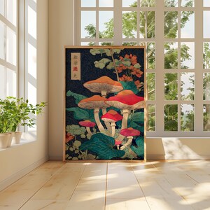 May include: A framed art print depicting stylized mushrooms with red and orange caps against a dark blue backdrop with green leaves. The print includes Japanese text in the upper left corner. The artwork is in a wooden frame.