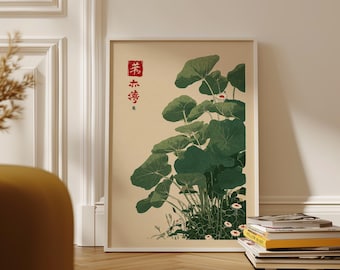 May include: A framed botanical print featuring a cluster of large, green leaves with small white flowers. The print has Japanese text in red on the upper left corner. The artwork is displayed on a light beige background.